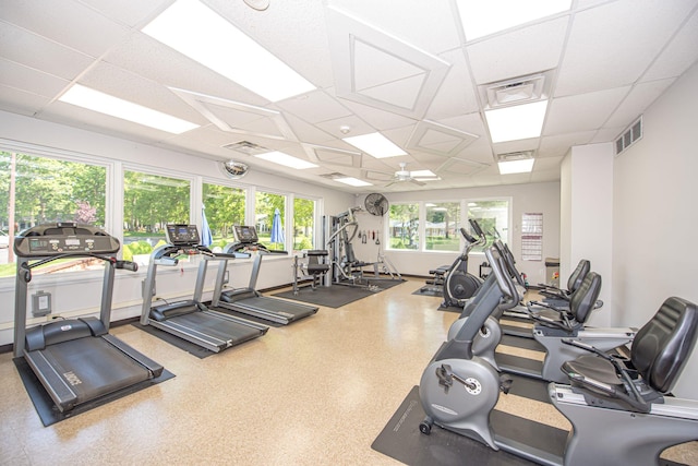 exercise room with a paneled ceiling and ceiling fan