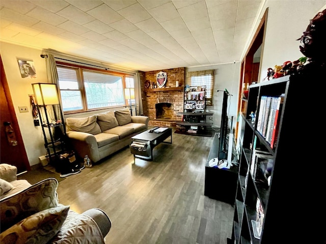 living room with hardwood / wood-style flooring and a brick fireplace