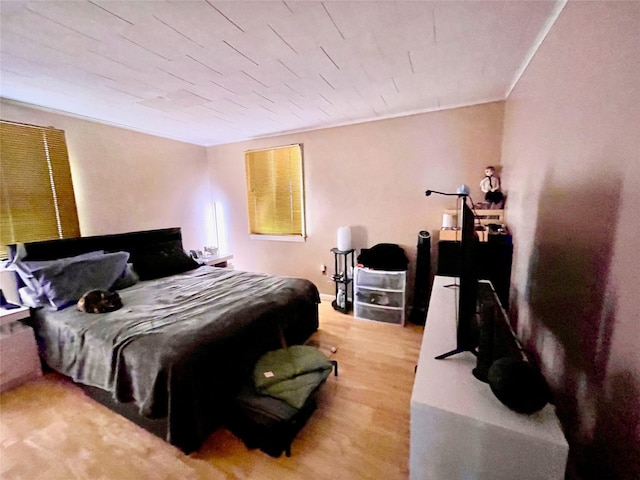 bedroom with light hardwood / wood-style floors and ornamental molding