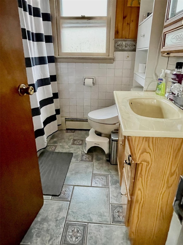 bathroom featuring vanity, toilet, tile walls, and a baseboard heating unit