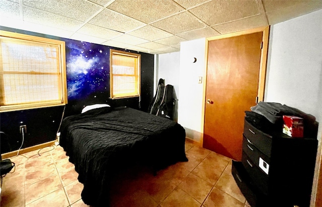 bedroom featuring tile patterned flooring and a drop ceiling