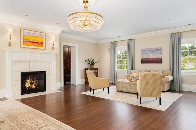 living room with dark hardwood / wood-style floors, an inviting chandelier, crown molding, and plenty of natural light