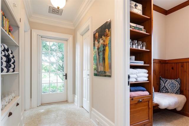 doorway with ornamental molding, a wealth of natural light, and wood walls