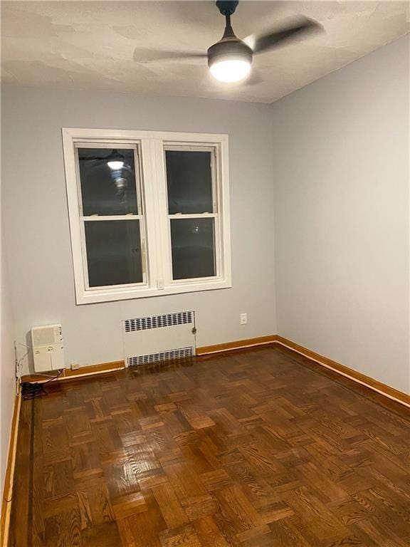 unfurnished room featuring dark parquet flooring and radiator