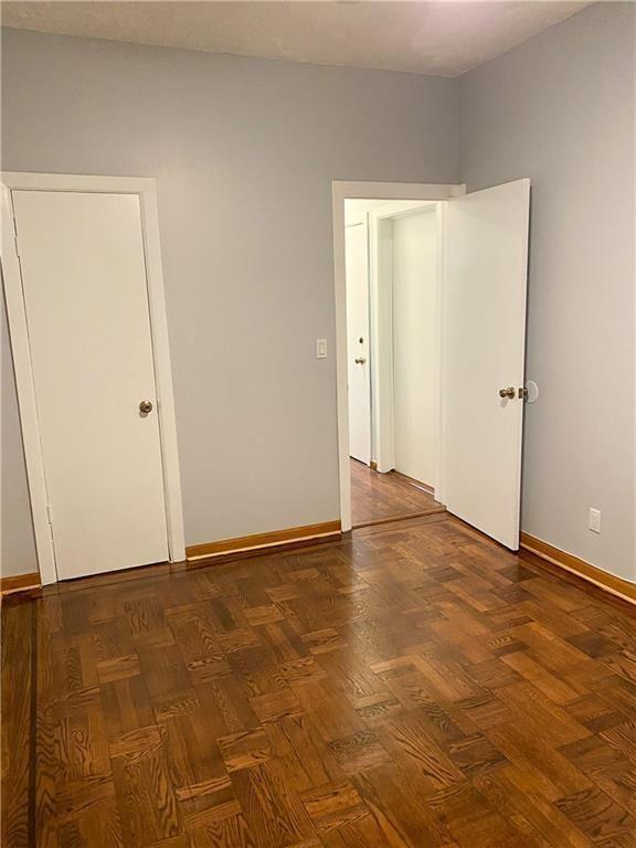 unfurnished room featuring dark parquet flooring