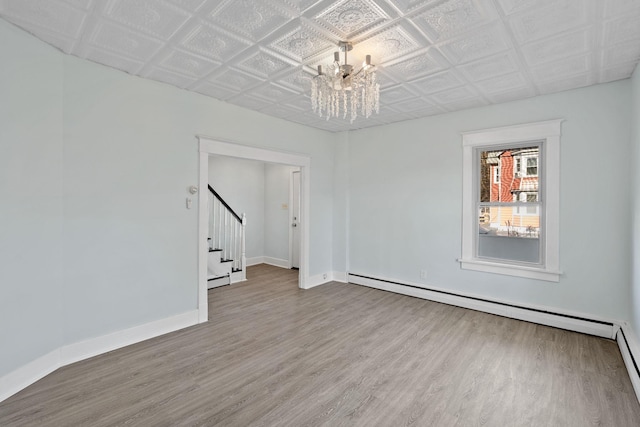 29 Thompson St, Port Jervis, NY 12771 - spare room with baseboards, stairs, wood finished floors, an ornate ceiling, and an inviting chandelier
