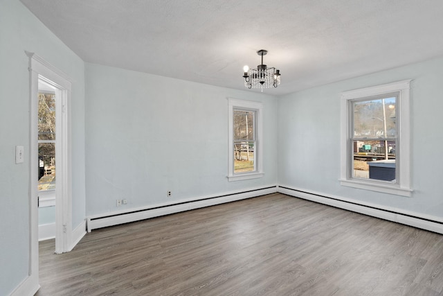 29 Thompson St, Port Jervis, NY 12771 - empty room with an inviting chandelier, a baseboard radiator, baseboards, and wood finished floors