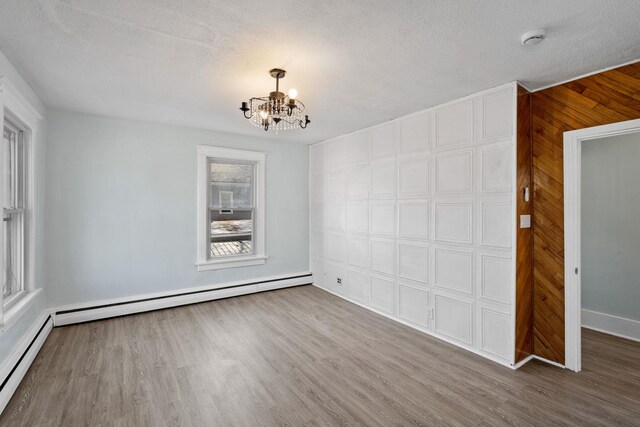 29 Thompson St, Port Jervis, NY 12771 - unfurnished dining area featuring a notable chandelier, a textured ceiling, a baseboard heating unit, and wood finished floors