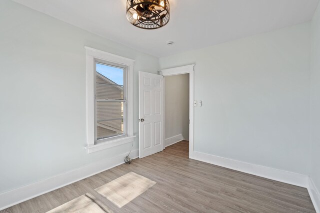29 Thompson St, Port Jervis, NY 12771 - empty room featuring baseboards, a chandelier, and light wood-type flooring