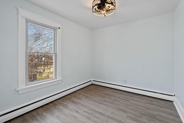 29 Thompson St, Port Jervis, NY 12771 - spare room with a baseboard radiator, an inviting chandelier, and wood finished floors