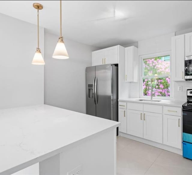 kitchen featuring appliances with stainless steel finishes, sink, white cabinetry, decorative light fixtures, and backsplash