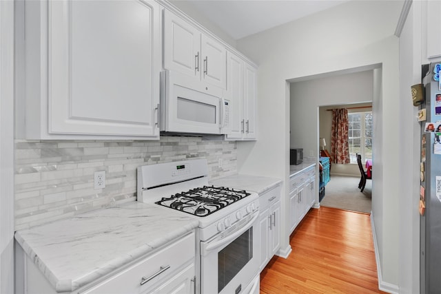 kitchen featuring white appliances, light wood-type flooring, and white cabinets