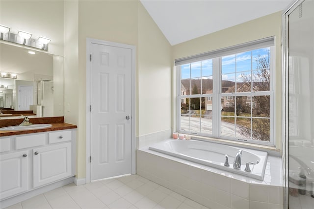 bathroom with tile patterned flooring, vaulted ceiling, independent shower and bath, and vanity