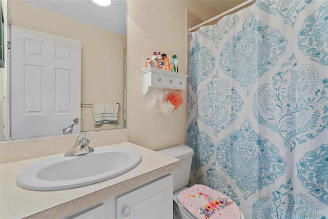 bathroom with toilet, vanity, and curtained shower