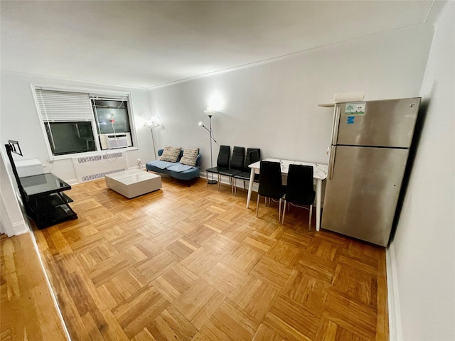 living room with light parquet flooring, radiator, and cooling unit