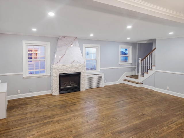 unfurnished living room featuring ornamental molding, a fireplace, and dark wood-type flooring