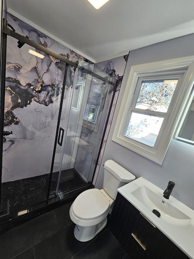 bathroom featuring vanity, toilet, and a shower with shower door