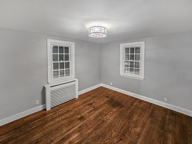 unfurnished room with dark hardwood / wood-style floors