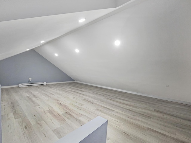 additional living space with light hardwood / wood-style flooring, a baseboard radiator, and lofted ceiling