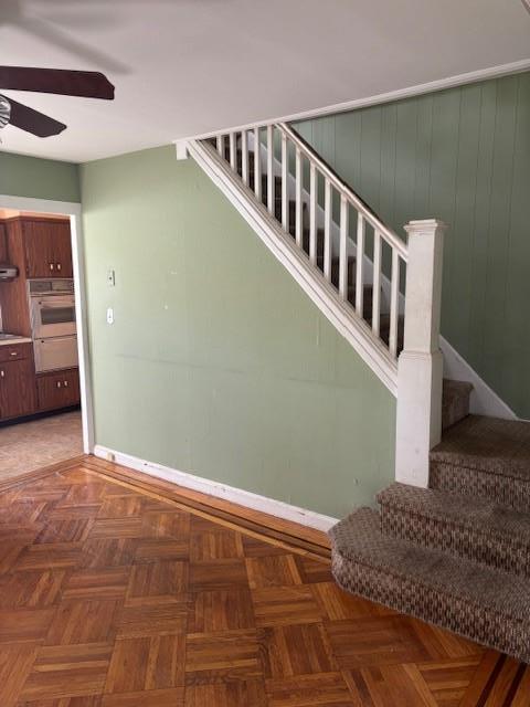 stairway with parquet floors and ceiling fan