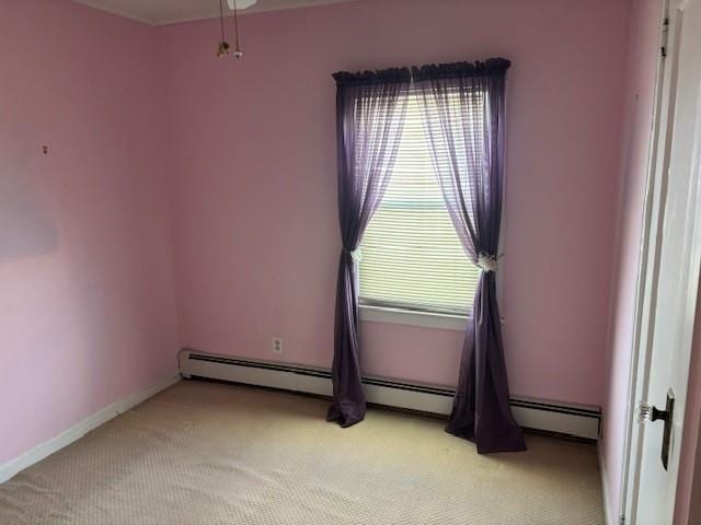 carpeted spare room featuring a baseboard heating unit