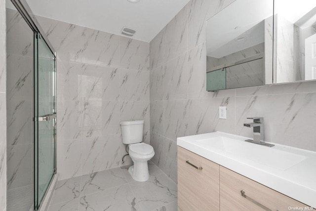 bathroom featuring vanity, a shower with shower door, tile walls, and toilet