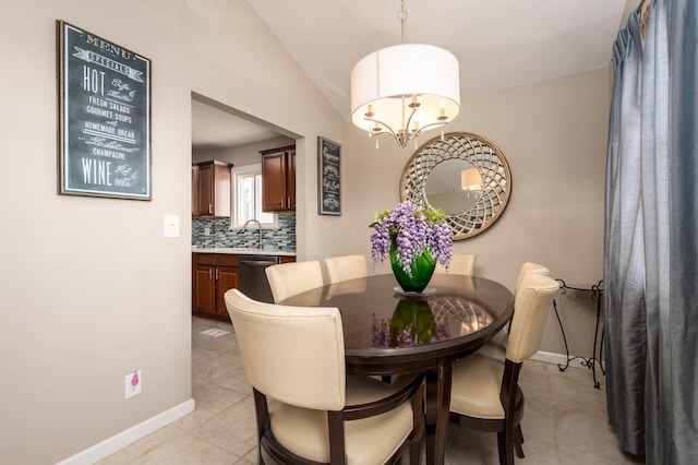 tiled dining room featuring vaulted ceiling, a chandelier, and sink