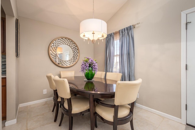 dining room featuring light tile patterned floors, vaulted ceiling, and a notable chandelier