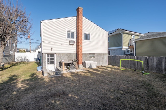 back of house with cooling unit and a yard