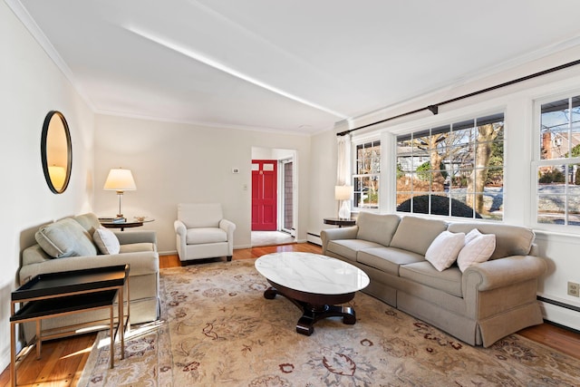 living room with wood-type flooring, a baseboard heating unit, and ornamental molding