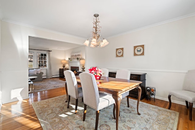 dining room featuring an inviting chandelier, ornamental molding, and light hardwood / wood-style flooring