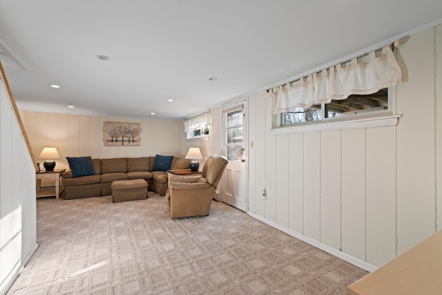 living room featuring light carpet and wood walls