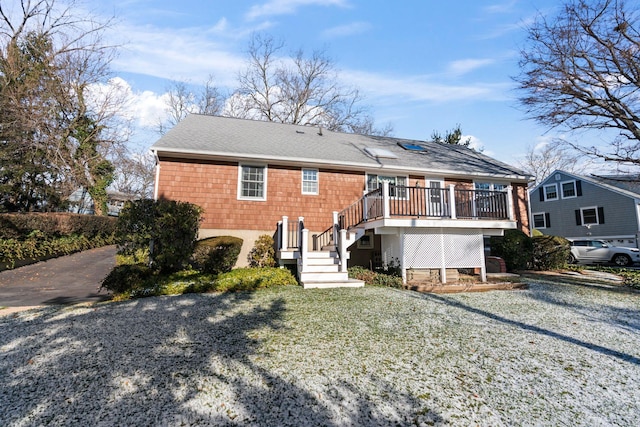 view of front of home featuring a front yard and a wooden deck