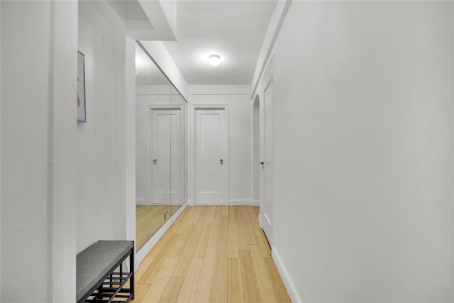 hallway with light wood-style flooring and baseboards