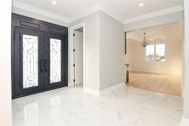 foyer entrance with crown molding, an inviting chandelier, and french doors