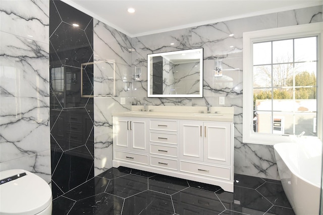 bathroom featuring ornamental molding, tile walls, vanity, and a washtub