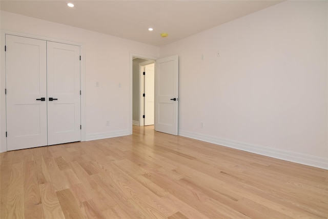 unfurnished bedroom featuring a closet and light wood-type flooring