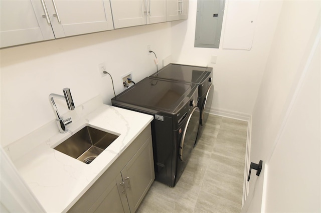 clothes washing area featuring cabinets, sink, electric panel, and independent washer and dryer