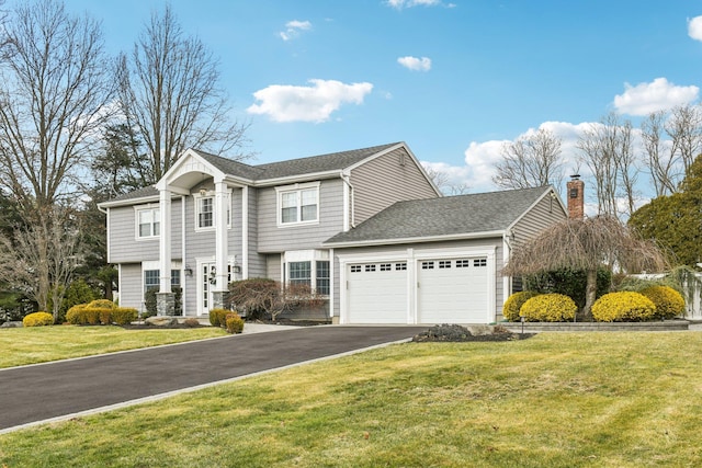 view of front of home with a front yard and a garage