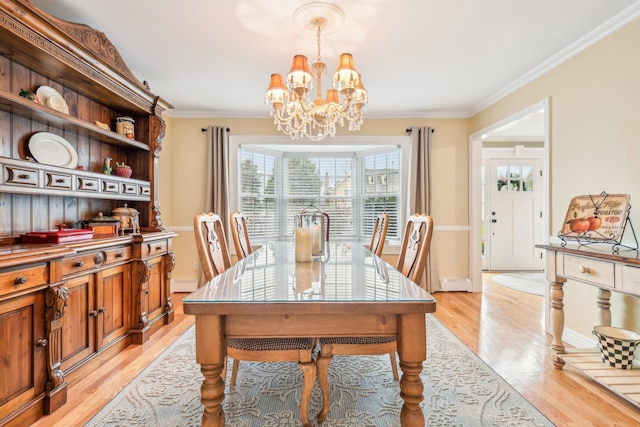 dining space with a chandelier, light hardwood / wood-style floors, and crown molding