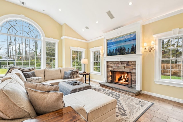 living room featuring a stone fireplace, lofted ceiling, and ornamental molding