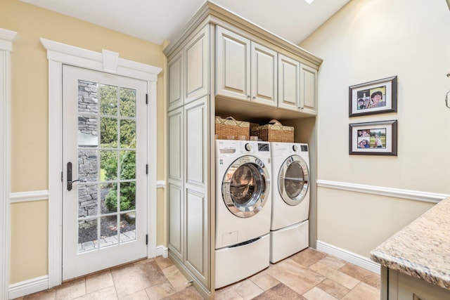 clothes washing area with cabinets and washing machine and dryer