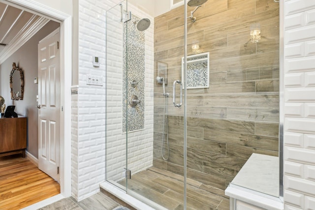 bathroom with an enclosed shower and ornamental molding