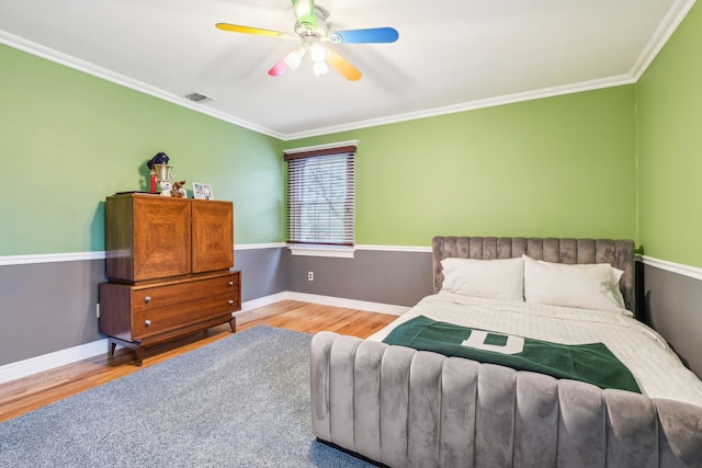 bedroom with hardwood / wood-style flooring, ceiling fan, and crown molding