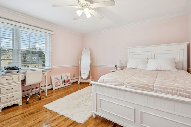 bedroom with light wood-type flooring, baseboard heating, ceiling fan, and ornamental molding