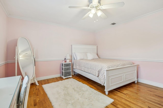 bedroom featuring light hardwood / wood-style flooring, ceiling fan, and ornamental molding