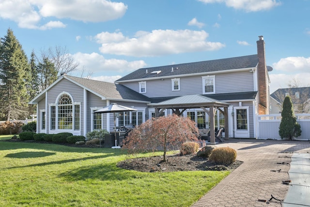 rear view of house with a gazebo and a yard