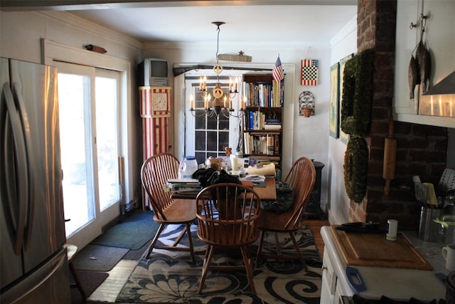 dining space with ornamental molding and a notable chandelier