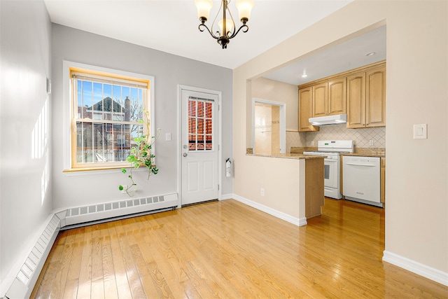 kitchen with white appliances, pendant lighting, tasteful backsplash, baseboard heating, and an inviting chandelier