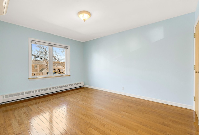 empty room featuring light hardwood / wood-style floors and a baseboard radiator